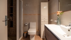A modern bathroom with a toilet, sink, and mirror. - Perla 5 - Charming Front-Row Apartment (Fuengirola)