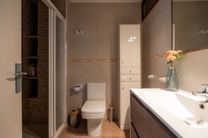A modern bathroom with a toilet, sink, and mirror. - Perla 5 - Charming Front-Row Apartment (Fuengirola)