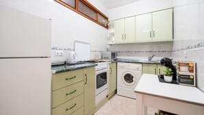 A compact kitchen with a built-in oven, microwave, and washing machine. - Perla 5 - Charming Front-Row Apartment (Fuengirola)