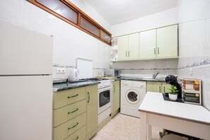A compact kitchen with a built-in oven, microwave, and washing machine. - Perla 5 - Charming Front-Row Apartment (Fuengirola)