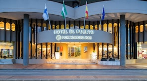 Hotel El Puerto with a prominent entrance, multiple flags, and a sign for Pierre&Vacances. - Hotel El Puerto - Perfect Location Apartment (Fuengirola)