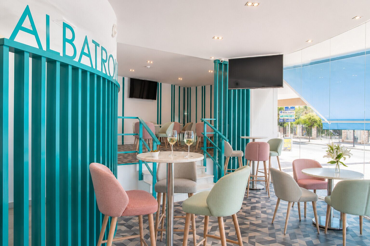 A modern interior with teal accents, a bar area, and seating arrangements.