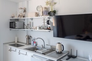 A modern kitchen with a flat-screen TV, built-in appliances, and a minimalist design. - Hotel El Puerto - Perfect Location Apartment (Fuengirola)