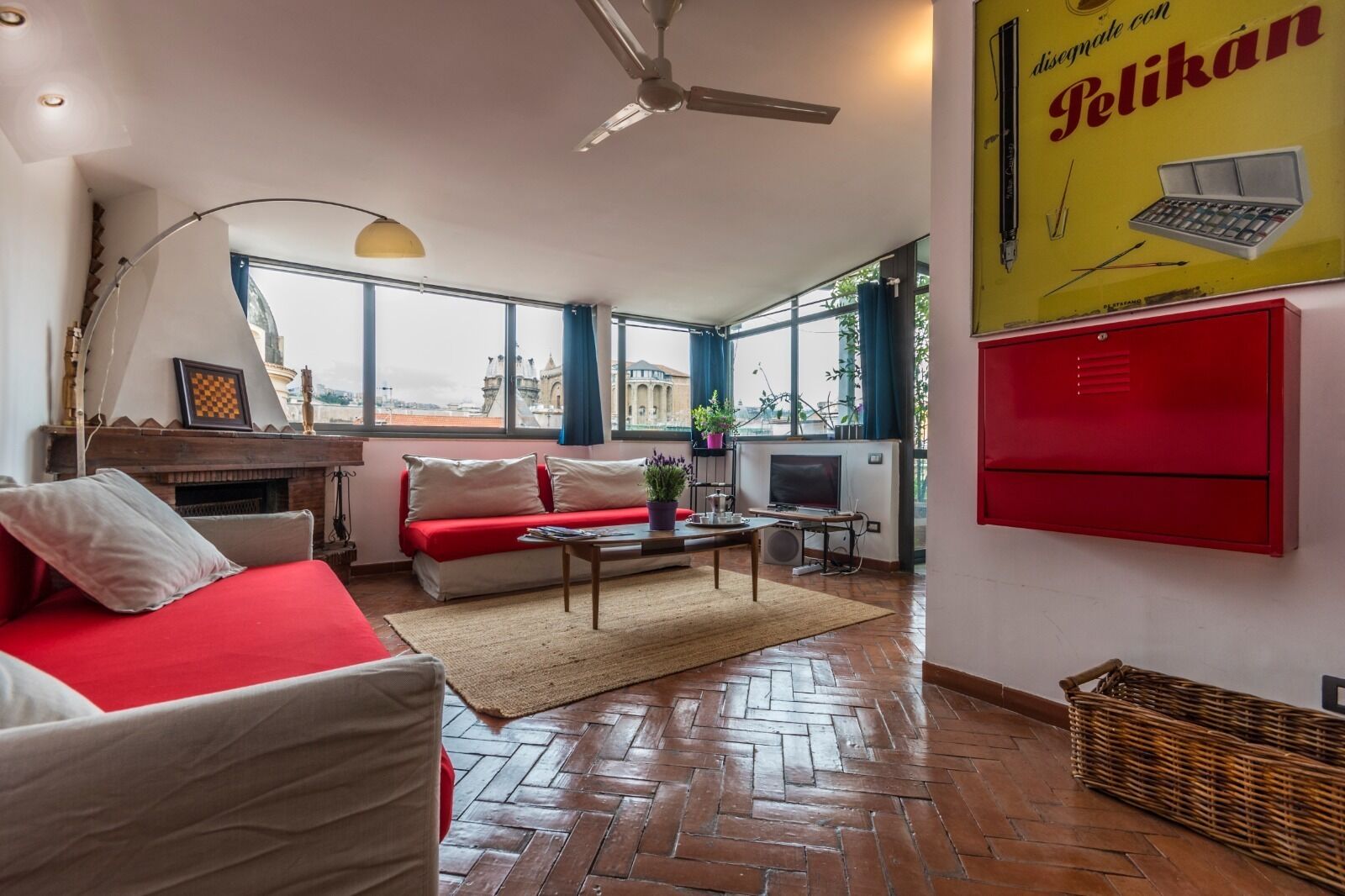 Una sala de estar amoblada con un sofá rojo, un televisor y una chimenea.