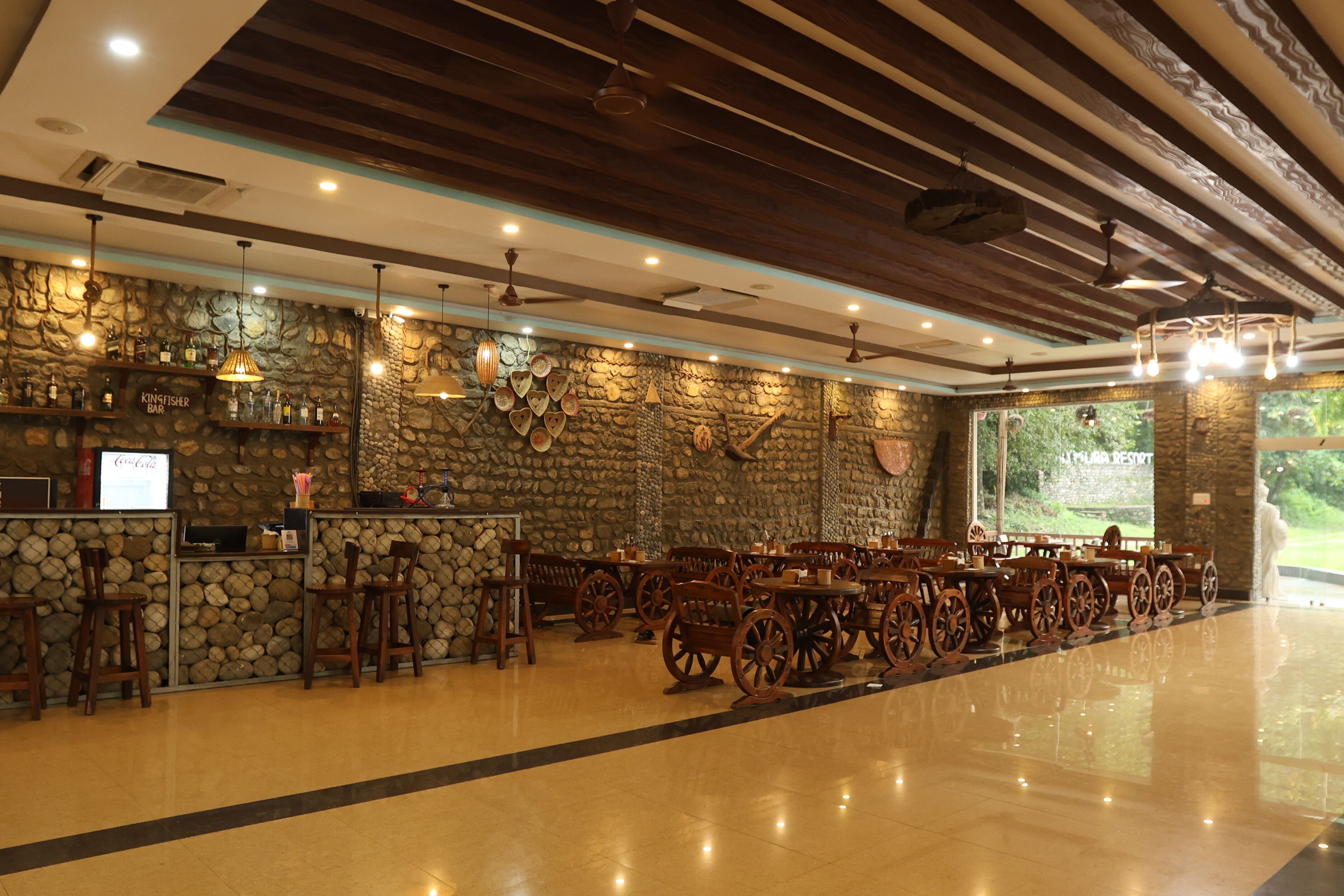 Un restaurante con pared de piedra, sillas y mesas de madera.