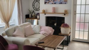 Una sala de estar con sofá, mesa de centro, chimenea y un cuadro en la pared.