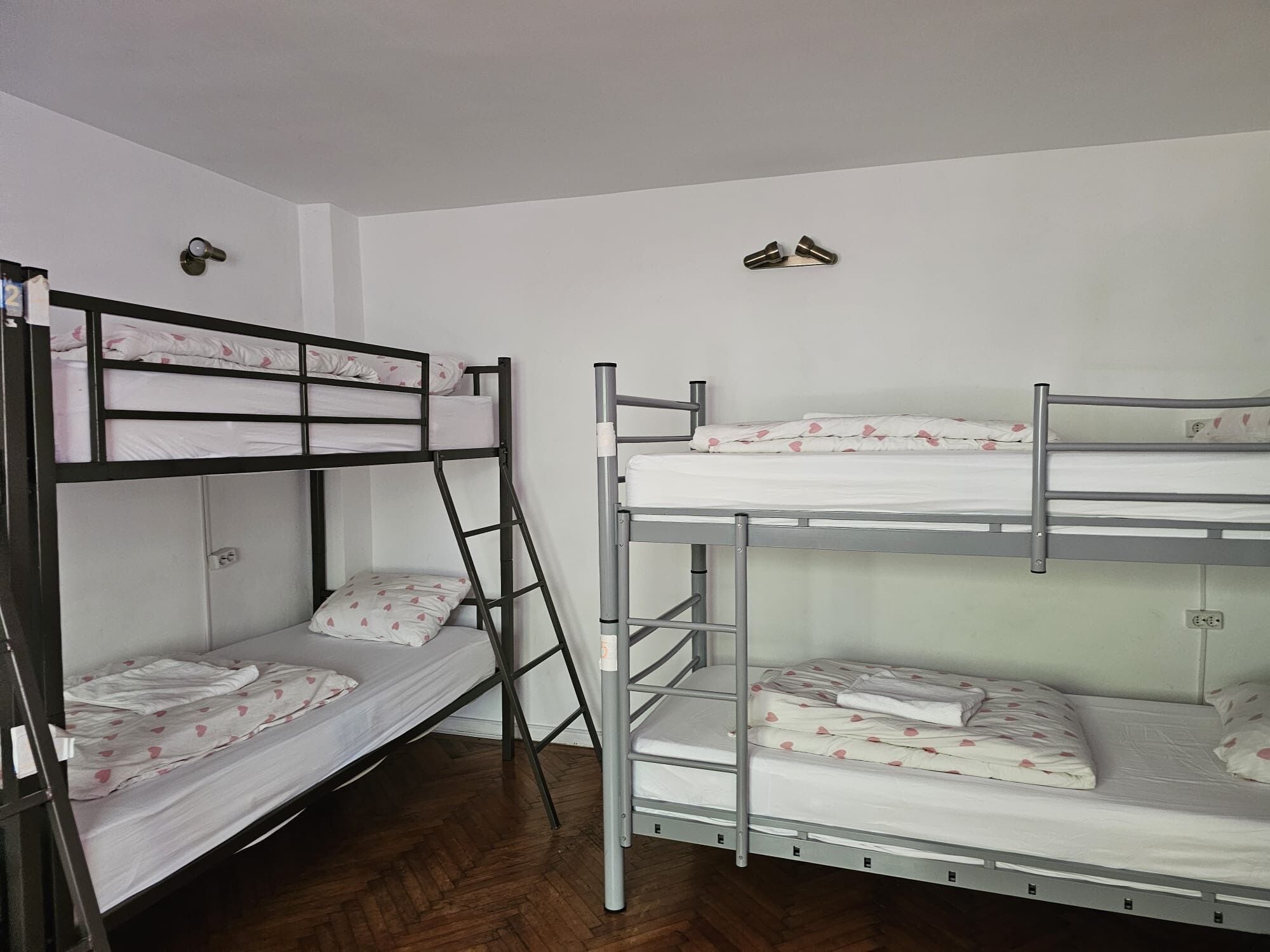 Quarto com beliches, dois beliches com colchão e almofadas, e uma escada para o beliche inferior.