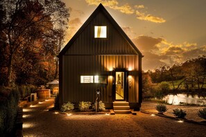 Eine Holzhütte mit Satteldach, einer Haustür und einem kleinen Fenster.