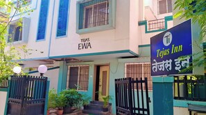 A building with a sign reading 'TEJAS EWA' and another sign for 'Tejas Inn' in a foreign language.