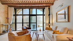 Ein Wohnzimmer mit Ledersofas, einem Couchtisch und einem großen Fenster mit Vorhängen.