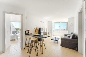 Ein modernes Wohnzimmer mit Essbereich, einer Couch und Blick ins Freie.