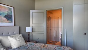 A bedroom with a bed, a nightstand, a lamp, a door leading to a bathroom, and a framed picture on the wall. - Gorgeous home in Kivik with WiFi (Kivik)