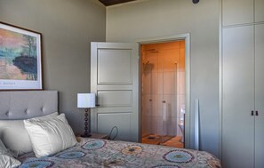A bedroom with a bed, a nightstand, a lamp, a door leading to a bathroom, and a framed picture on the wall. - Gorgeous home in Kivik with WiFi (Kivik)