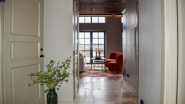 A hallway with a door, a vase with green foliage, a red chair, and a table with a bowl. - Gorgeous home in Kivik with WiFi (Kivik)
