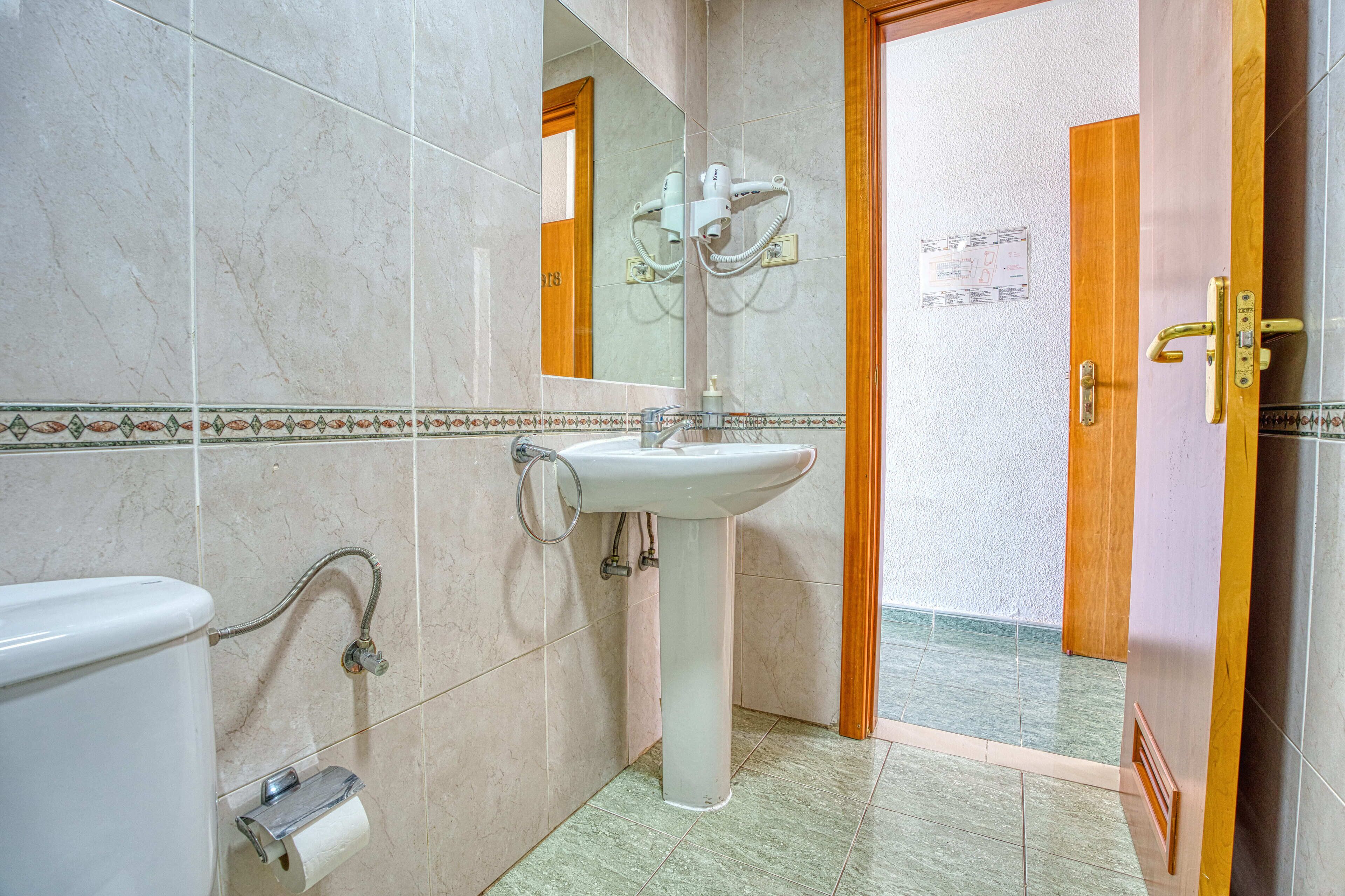 Ein Badezimmer mit Waschbecken, Toilette und Spiegel.