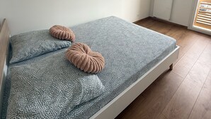 Un dormitorio con cama, radiador, lámpara colgante y un mapa enmarcado en la pared.