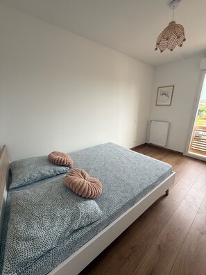 Ein Schlafzimmer mit einem Bett, einem Heizkörper, einer Pendelleuchte und einer gerahmten Karte an der Wand.