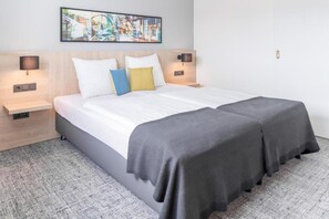 Una cama doble con dos mesitas de noche, un cabecero y una obra de arte colgada en la pared.