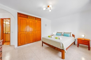Une chambre à coucher avec un lit, une table de chevet et une armoire.