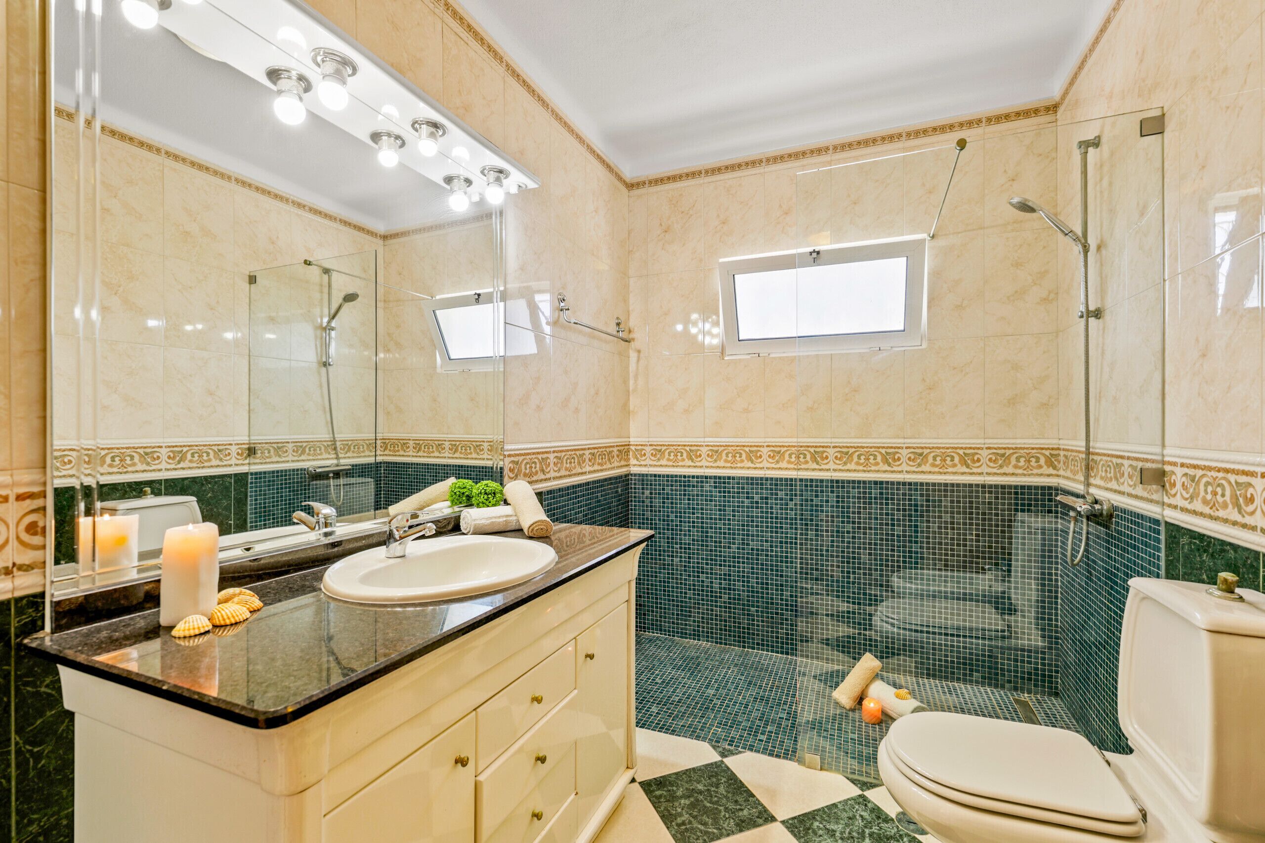 A bathroom with a sink, mirror, shower, and toilet.
