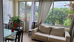 A living room with a sofa, chairs, a glass table, and a potted plant. - 3-bedroom house in serene Carry-le-Rouet with cool AC (Carry-le-Rouet)