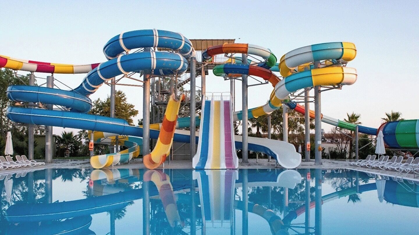 Een waterpark met verschillende glijbanen en een zwembad.