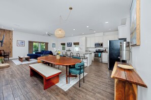 A modern kitchen with white cabinets, a built-in microwave, and a stainless steel refrigerator. - Home Near Belleair Beach (Largo)
