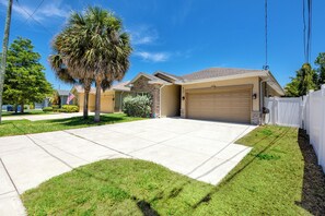 A residential house with a garage, a lawn, and a palm tree. - Home Near Belleair Beach (Largo)