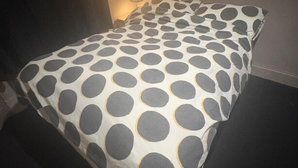 A bed with a polka dot bedspread. - Glasgow City Escape - 2 Bedroom Apartment (Glasgow)