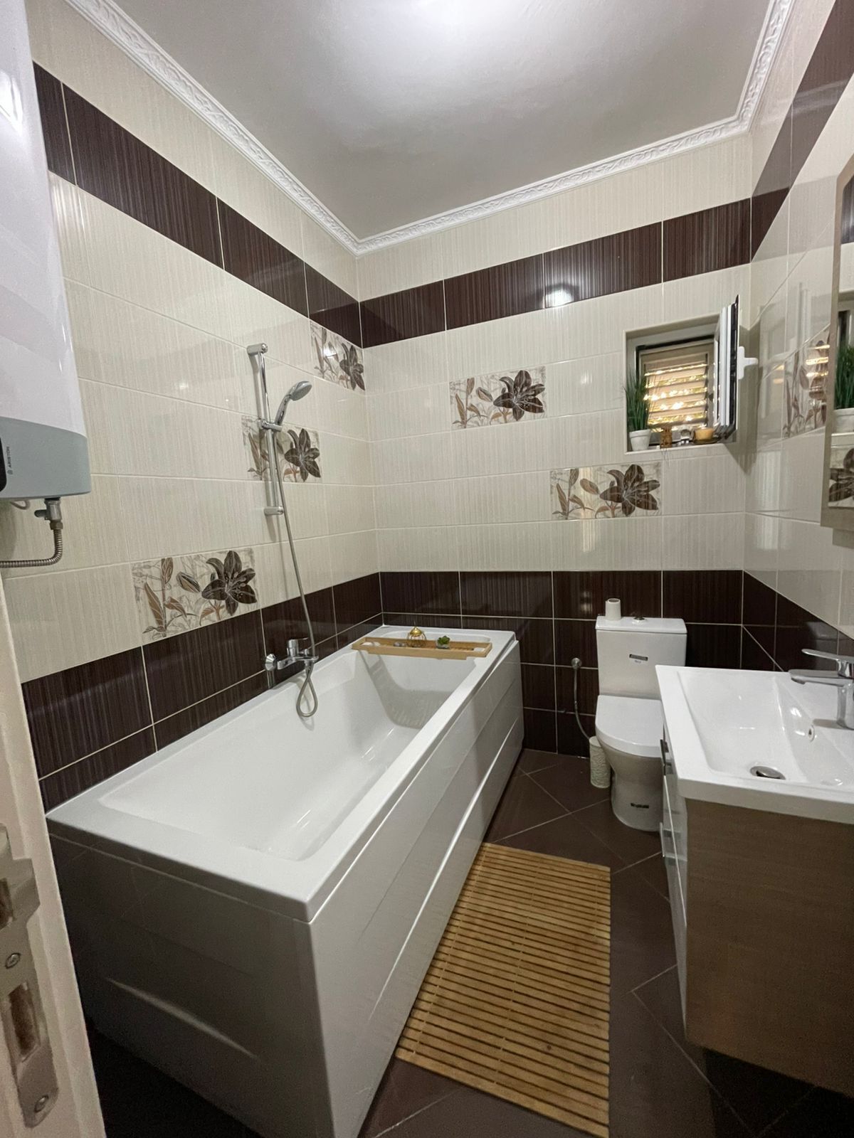 Et badeværelse med badekar, toilet og håndvask.