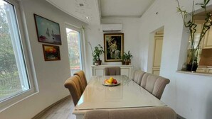 En matplats med ett glasbord, beige stolar och en fruktskål.