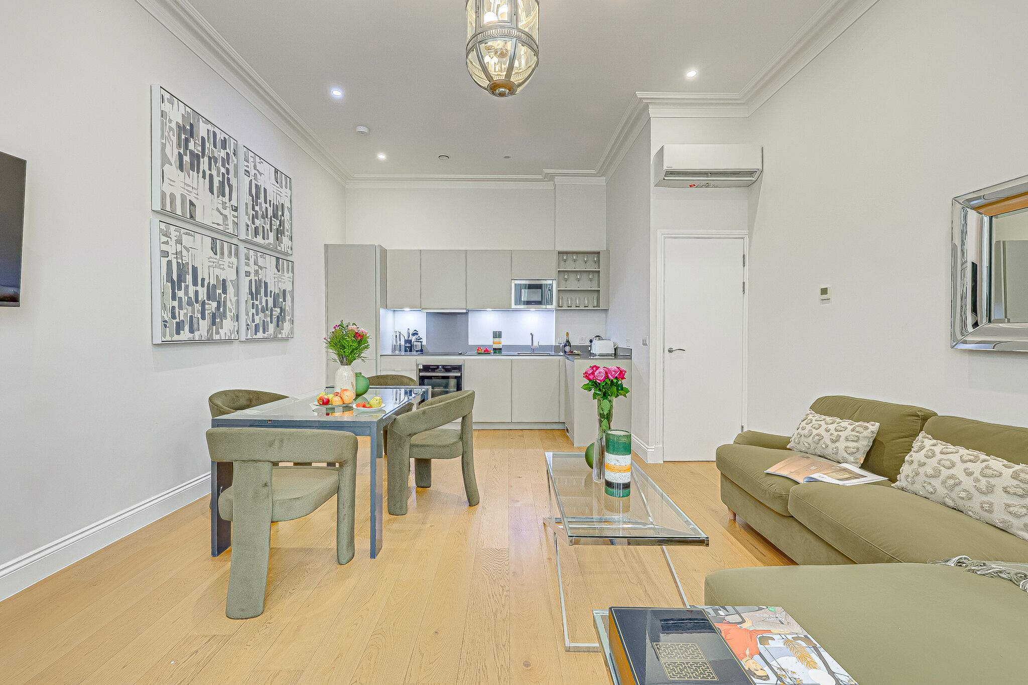 A modern apartment with a dining area, kitchen, and living room.