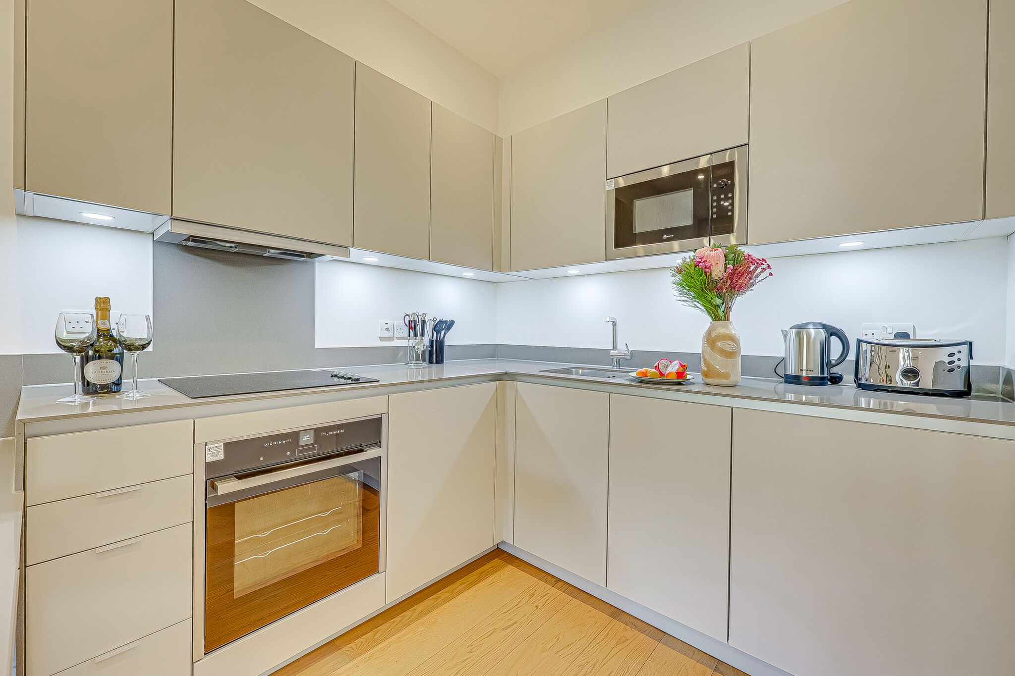 Una cocina moderna con electrodomésticos integrados, un microondas y un lavabo.