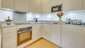Una cocina moderna con electrodomésticos integrados, un microondas y un lavabo.
