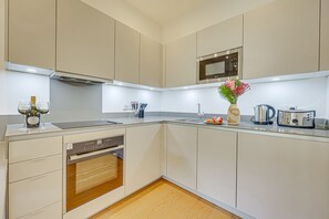 Una cocina moderna con electrodomésticos integrados, un microondas y un lavabo.