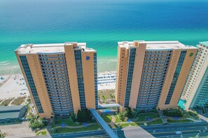 A high-rise hotel with a beachfront view, featuring multiple balconies and a pool area. - 2 Oceanfront Masters + Bunk, Sleeps 10, PCB (Panama City Beach)