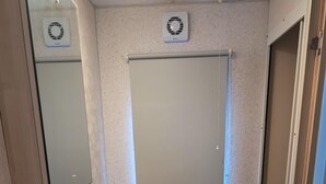 Un baño con lavamanos, inodoro y ventana con lámpara.