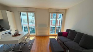 Un appartement moderne comprenant une cuisine, un coin repas et un salon.