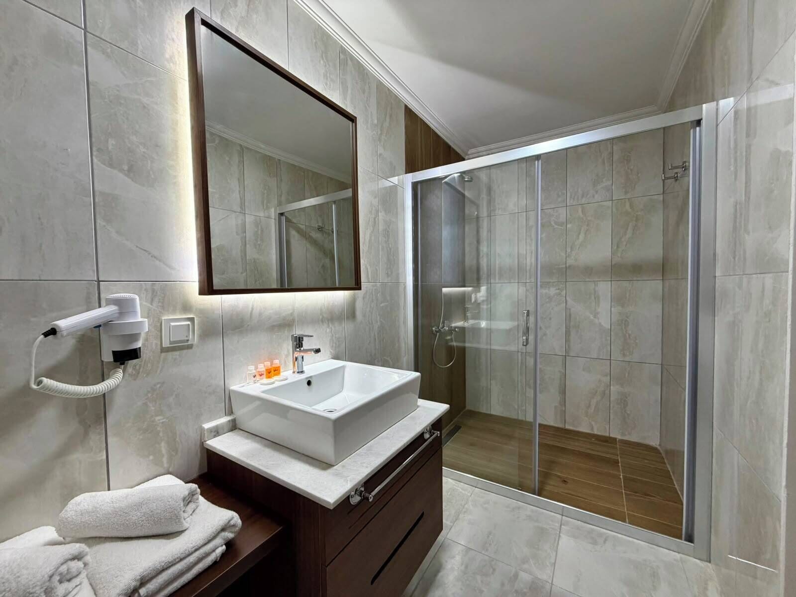 Habitación estándar con 2 camas individuales, balcón, vistas al mar | Baño | Ducha, cabezal de ducha tipo lluvia, secador de pelo y toallas
