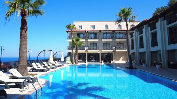 Un hotel con piscina, tumbonas y palmeras.