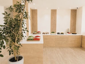 Una cuina moderna amb taulell de fusta, una planta en test i diferents aliments.