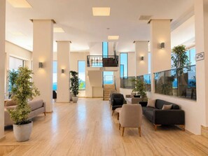 A spacious interior with a central staircase, multiple seating areas, and large windows offering views. - ALTAMARE HOTEL (+14)  Adults Only (Kusadasi)