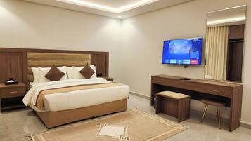 Una habitación de hotel moderna con una cama grande, televisión, escritorio y espejo.