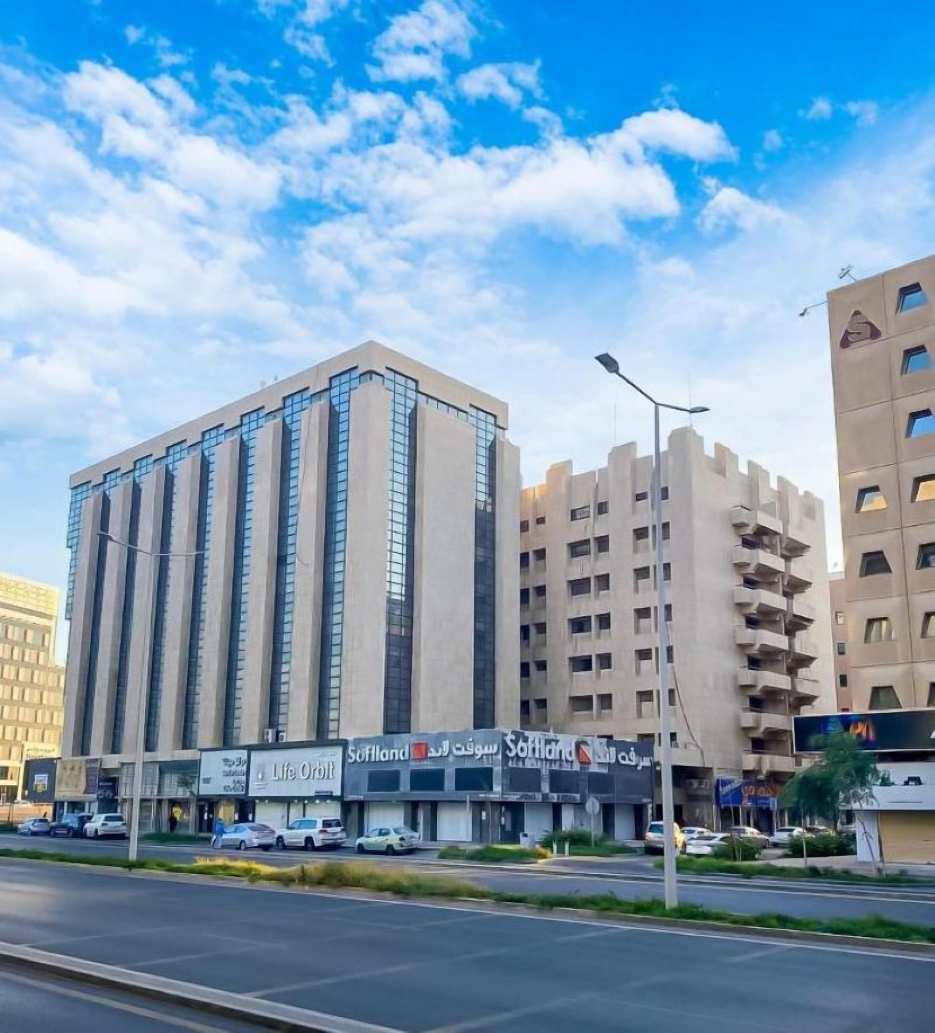 A multi-story building with a modern design, featuring a prominent vertical structure and a series of windows.