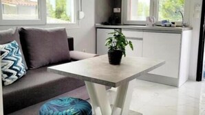 Une cuisine moderne avec un coin repas, un canapé et un petit pouf rond.
