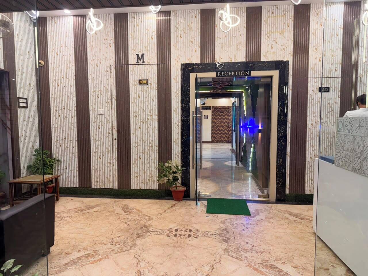 A reception area with a marble floor, vertical striped wallpaper, and a reception desk.