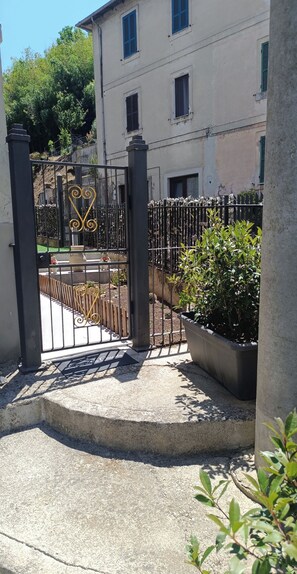 A gated entrance with a metal gate and a concrete pathway leading to a building with multiple windows and a balcony. - Between the City and the Waterfall, modern and welcoming - Free Parking & Free Entertainment (Terni)