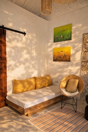 A cozy room with a wooden bed, a wicker chair, and two paintings on the wall. - Luxury 3-BR Villa, Canggu Berawa , Private Pool (Kec. Kuta Utara)