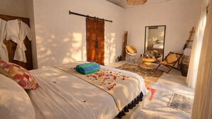 A bedroom with a bed, a wooden door, a mirror, a chair, and a small table. - Luxury 3-BR Villa, Canggu Berawa , Private Pool (Kec. Kuta Utara)