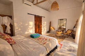 A bedroom with a bed, a wooden door, a mirror, a chair, and a small table. - Luxury 3-BR Villa, Canggu Berawa , Private Pool (Kec. Kuta Utara)